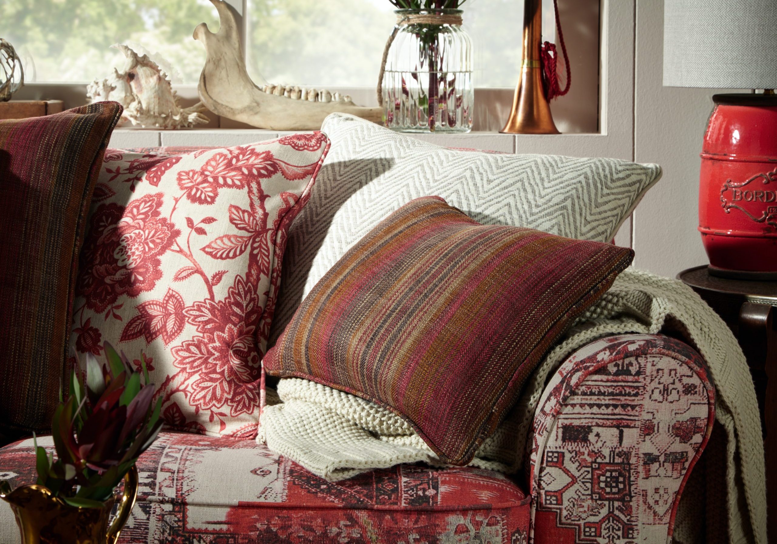 Des coussins de couleurs chaudes variées sur un fauteuil